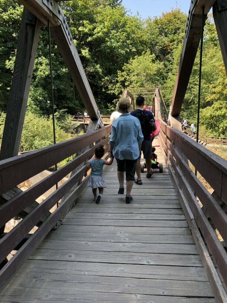 Grandma walking with granddaughter across a bridge at Tumwater Falls